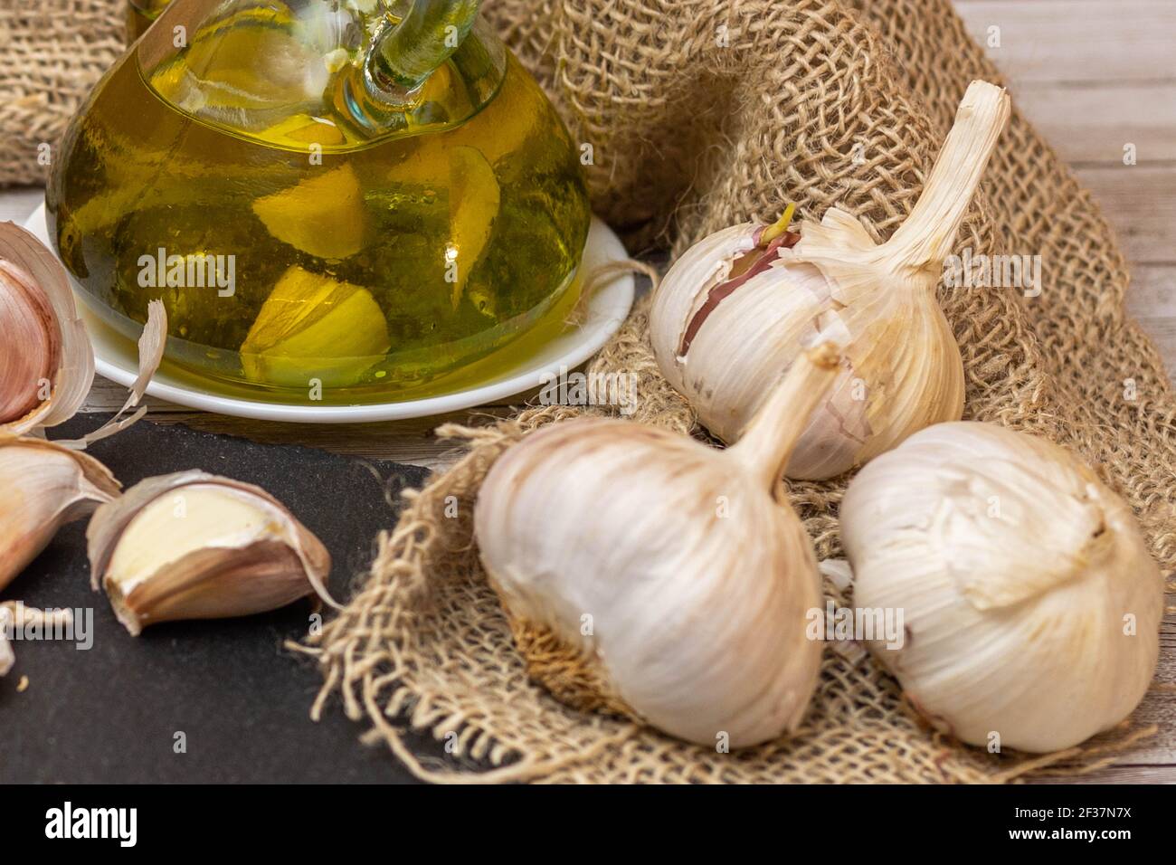 set of fresh garlic bulbs on burlap and extra virgin olive oil to make ...