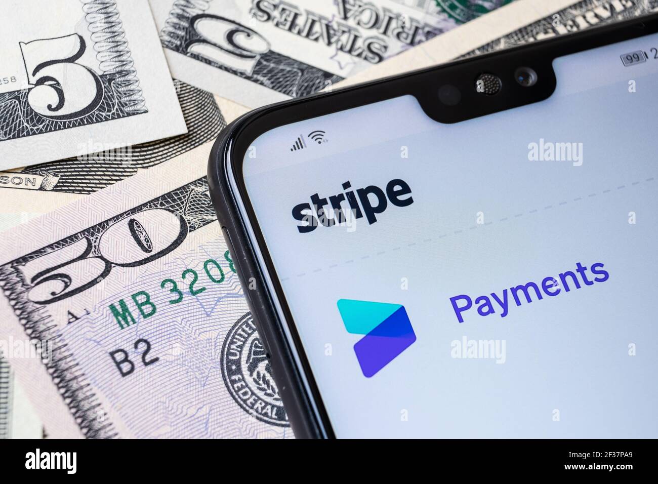 Stripe Payment provider website seen on the corner of smartphone placed on the dollar bills. Stafford, United Kingdom, March 14, 2021. Stock Photo