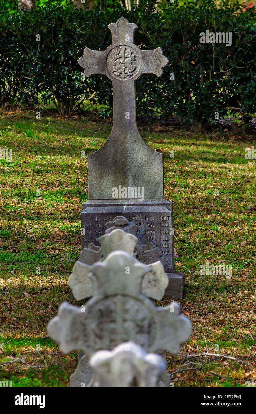 Headstones shaped in the form of Celtic crosses are arranged in a small parish cemetery at Spring Hill College, March 14, 2021, in Mobile, Alabama. Stock Photo