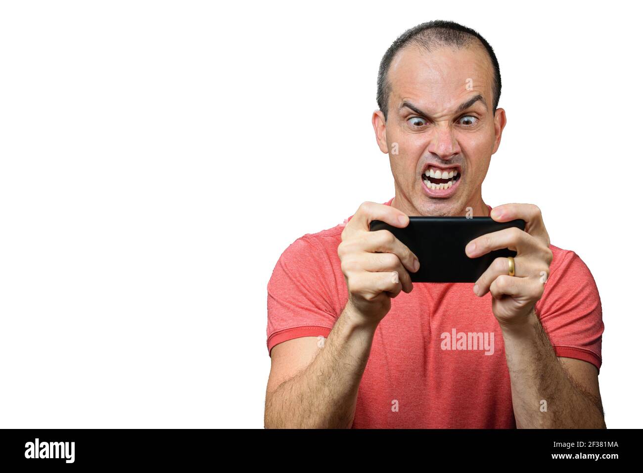 Mature man in casual clothing, with angry expression and holding smartphone horizontally. Stock Photo