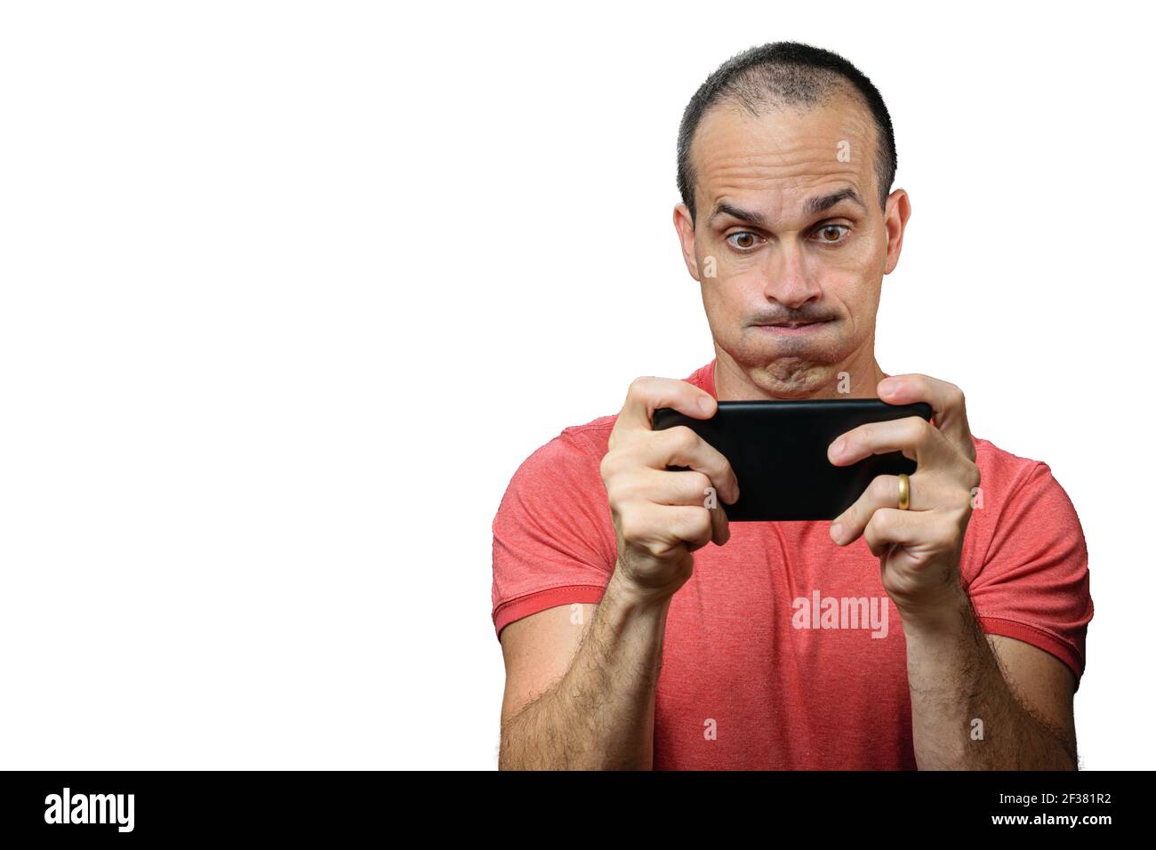 Mature man in casual clothes playing on the smartphone and making a funny face. Stock Photo