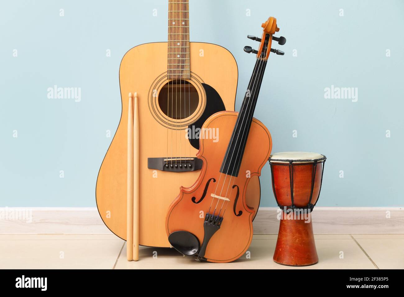 Different musical instruments near color wall Stock Photo Alamy