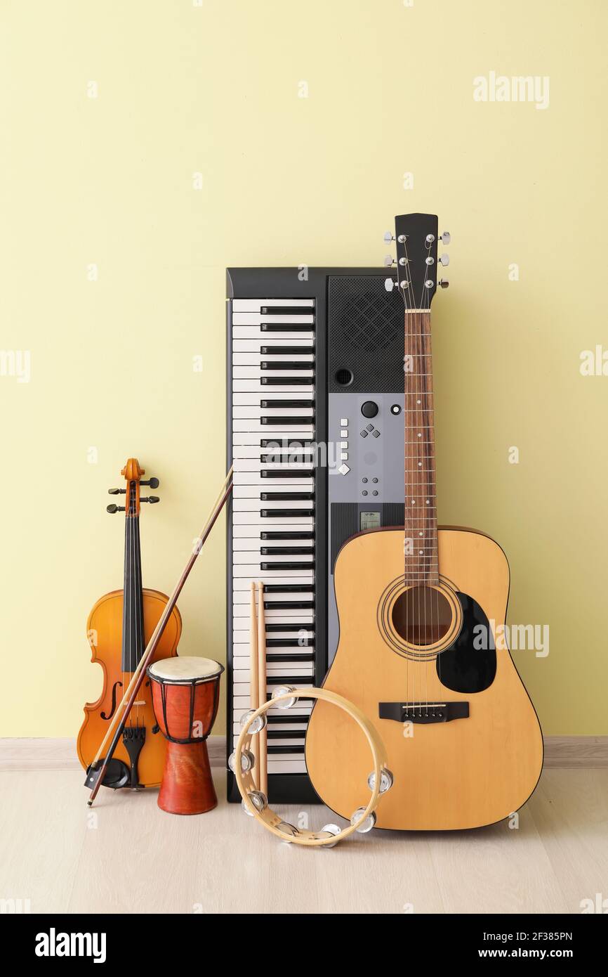 Different musical instruments near color wall Stock Photo - Alamy