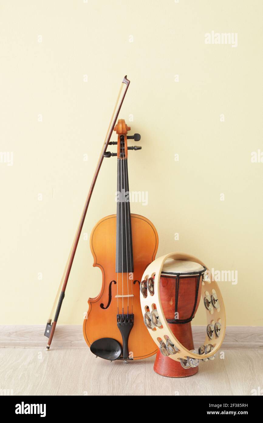 Different musical instruments near color wall Stock Photo Alamy