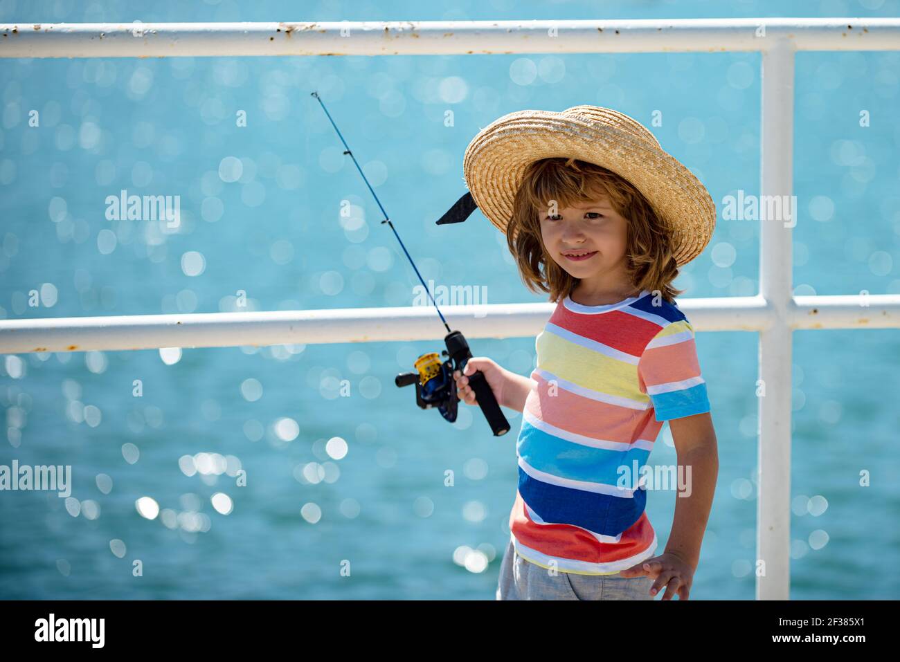 Kids fishing. Child fishing on the lake. Young fisher. Boy with spinner at  river.Boy fishing at jetty with rod Stock Photo - Alamy