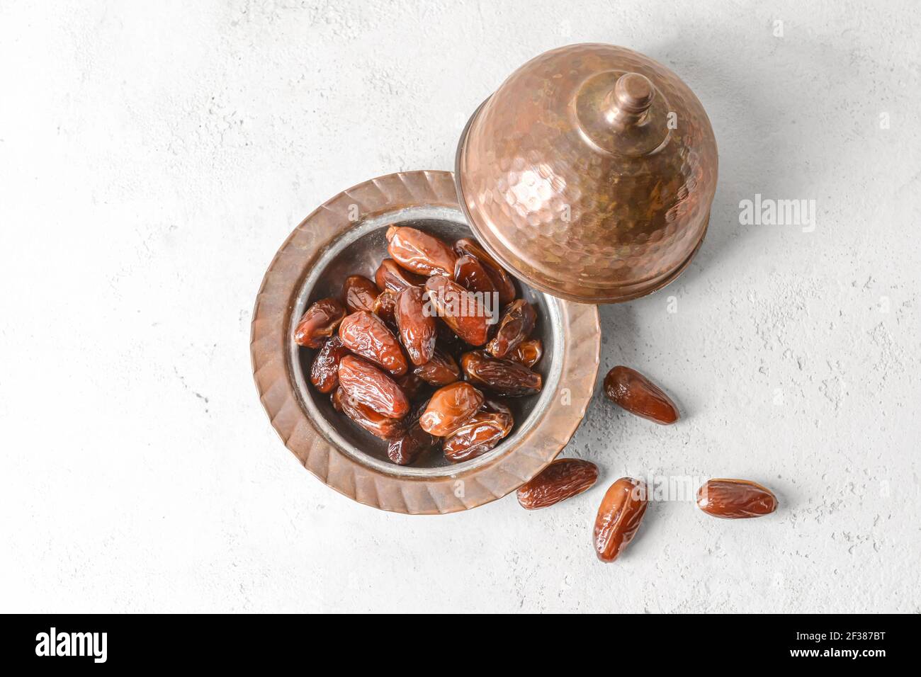 Bowl with sweet dried dates on light background Stock Photo - Alamy