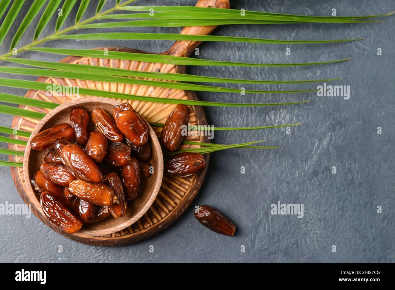 Bowl with sweet dried dates on dark background Stock Photo - Alamy