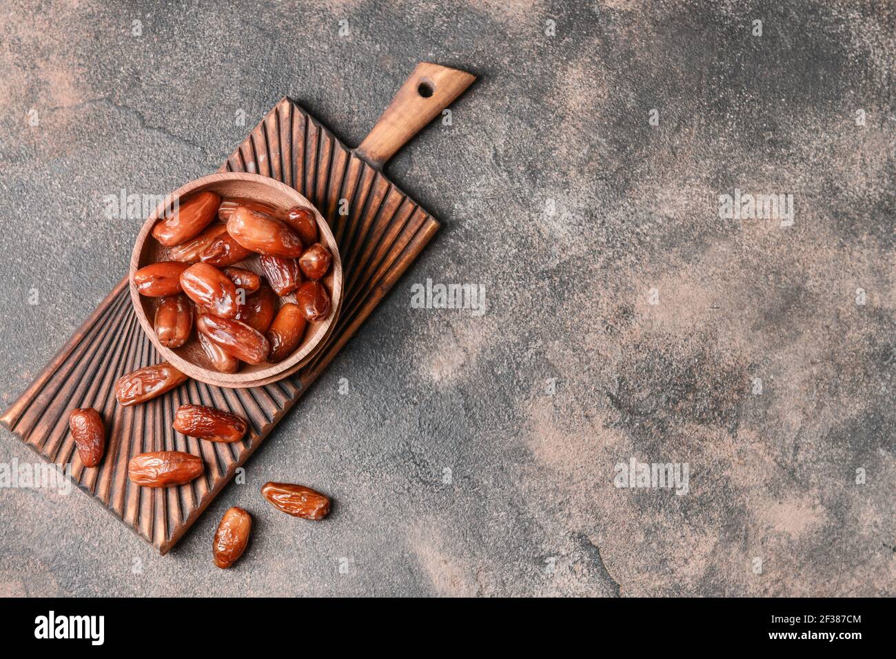 Bowl with sweet dried dates on grunge background Stock Photo - Alamy