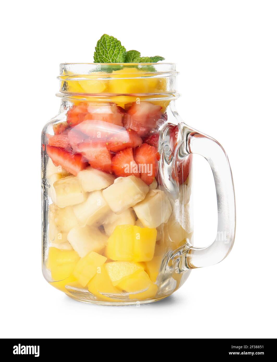 Mason jar with tropical fruit salad on white background Stock Photo - Alamy