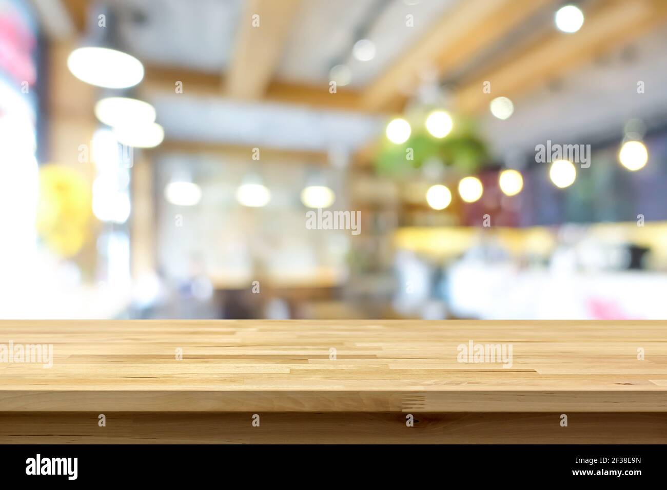 Wood table top on blur background of coffee shop (or restaurant