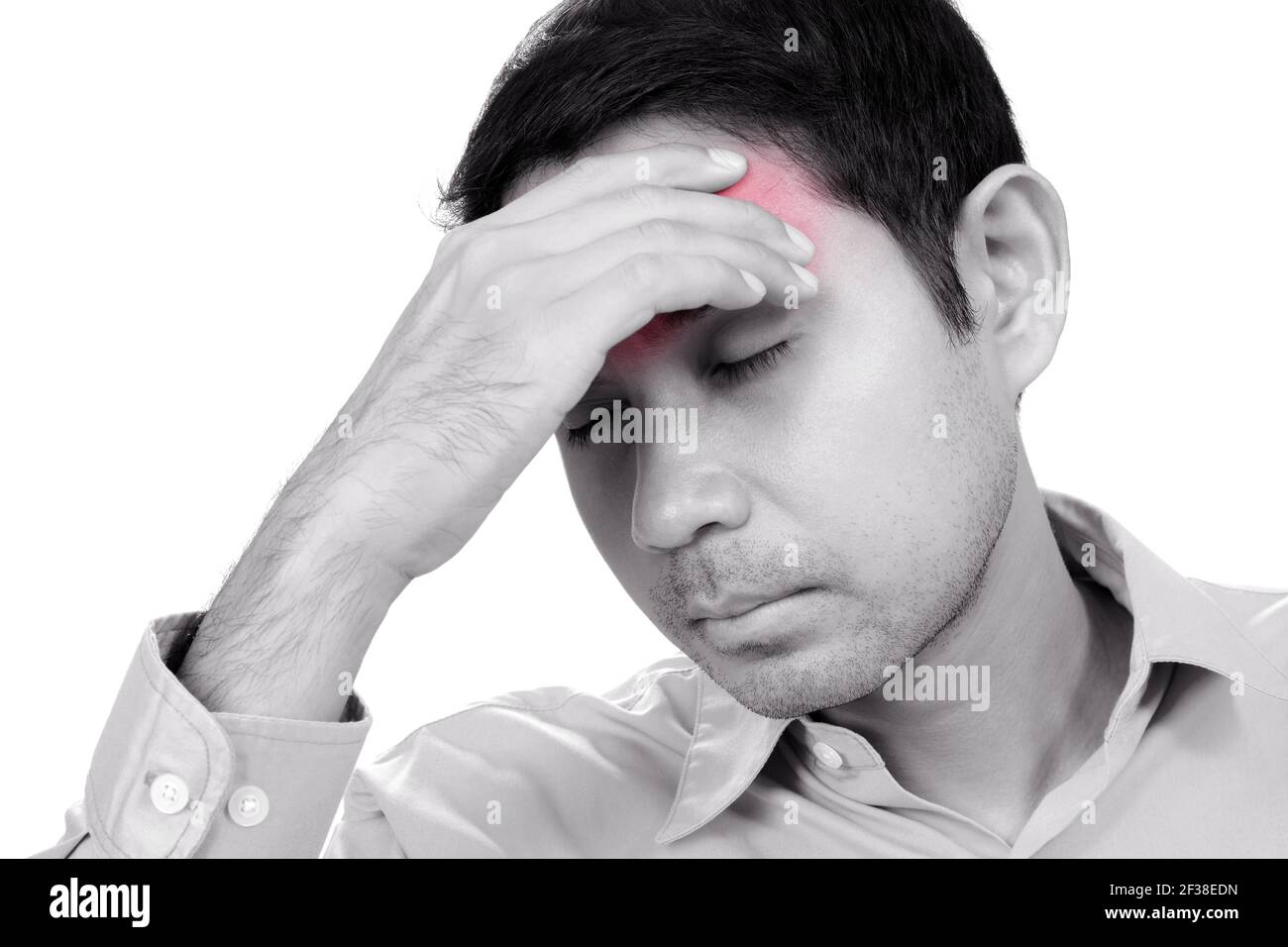 Young Asian man having headache with hand on his forehead - monochrome effect with red spot on pain area Stock Photo