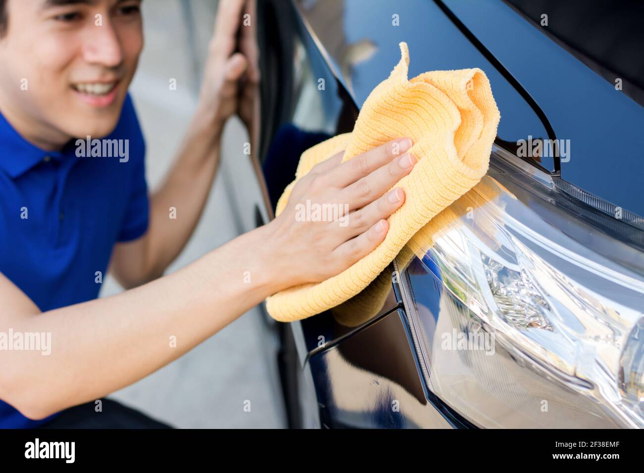 A man polishing (cleaning) car with microfiber cloth, car detailing or