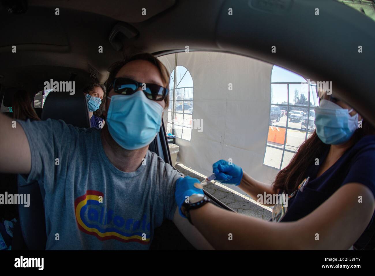 A man receives a Covid-19 shot at a Sutter Health drive through vaccination site in Santa Cruz, California.  March 2021 Stock Photo