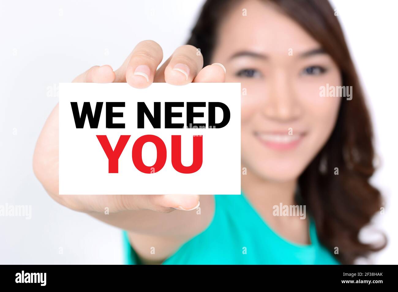 WE NEED YOU, message on the card shown by a woman Stock Photo