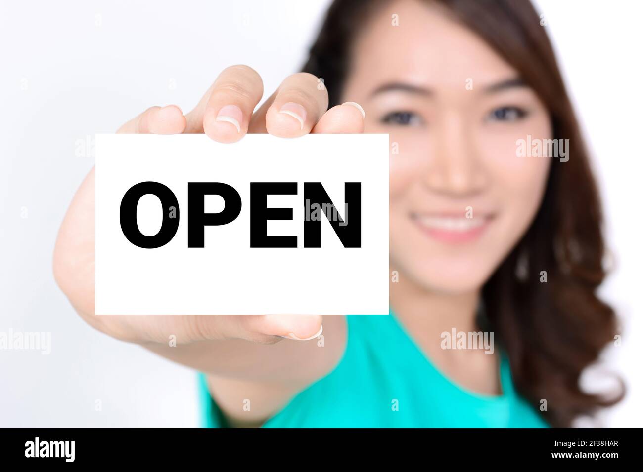 OPEN sign shown by smiling young woman Stock Photo