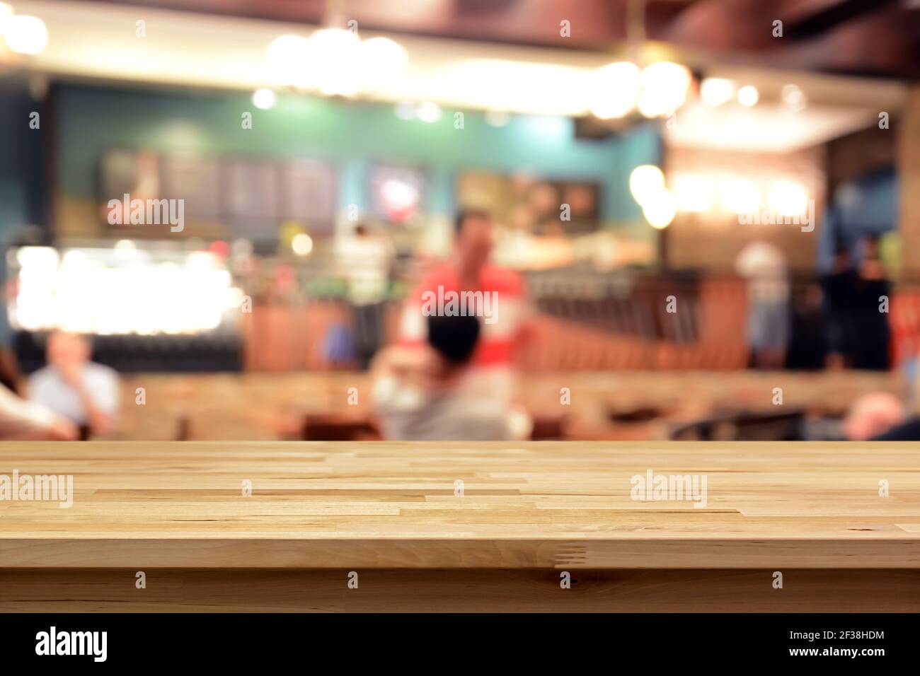 Wood table top on blur background of coffee shop interior with some people - can be used for display or montage your products Stock Photo