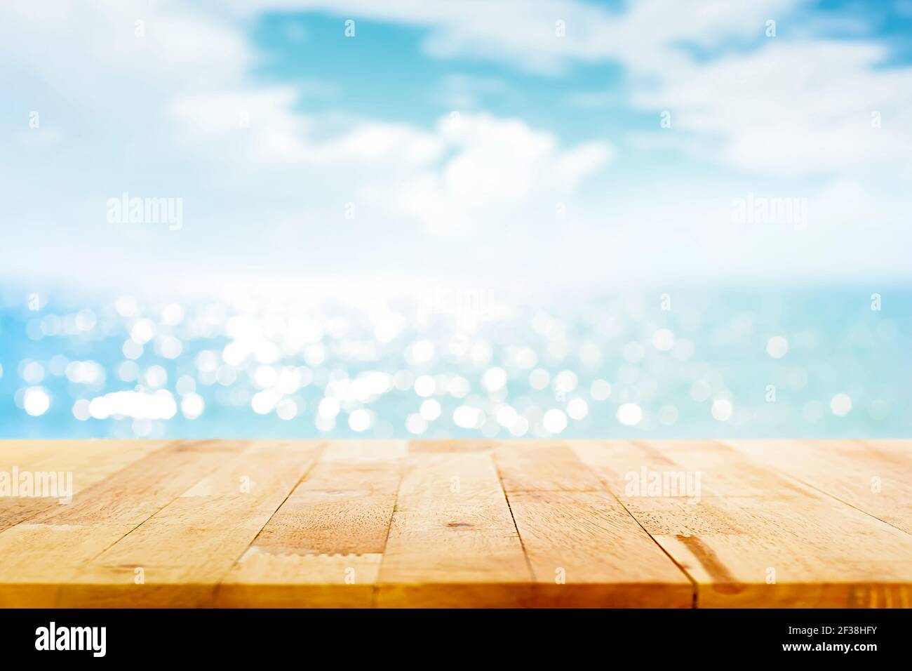 Wood table top on blur sparkling sea water and summer sky background - can be used for display or montage your products Stock Photo