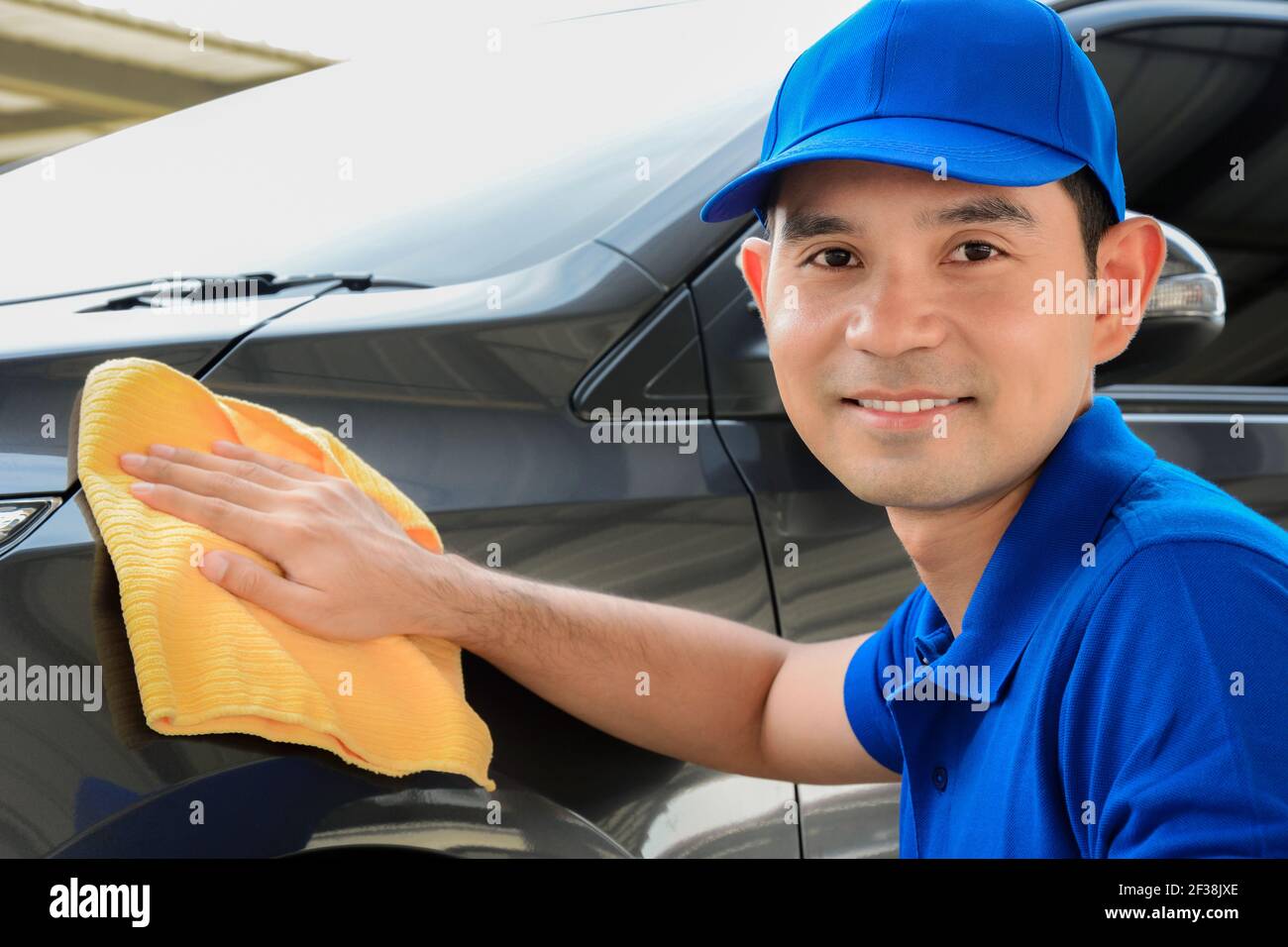 A man with smiling face cleaning car Stock Photo