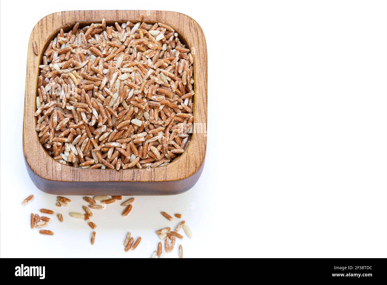 Raw red rice in a wooden cup isolated on white background Stock Photo ...