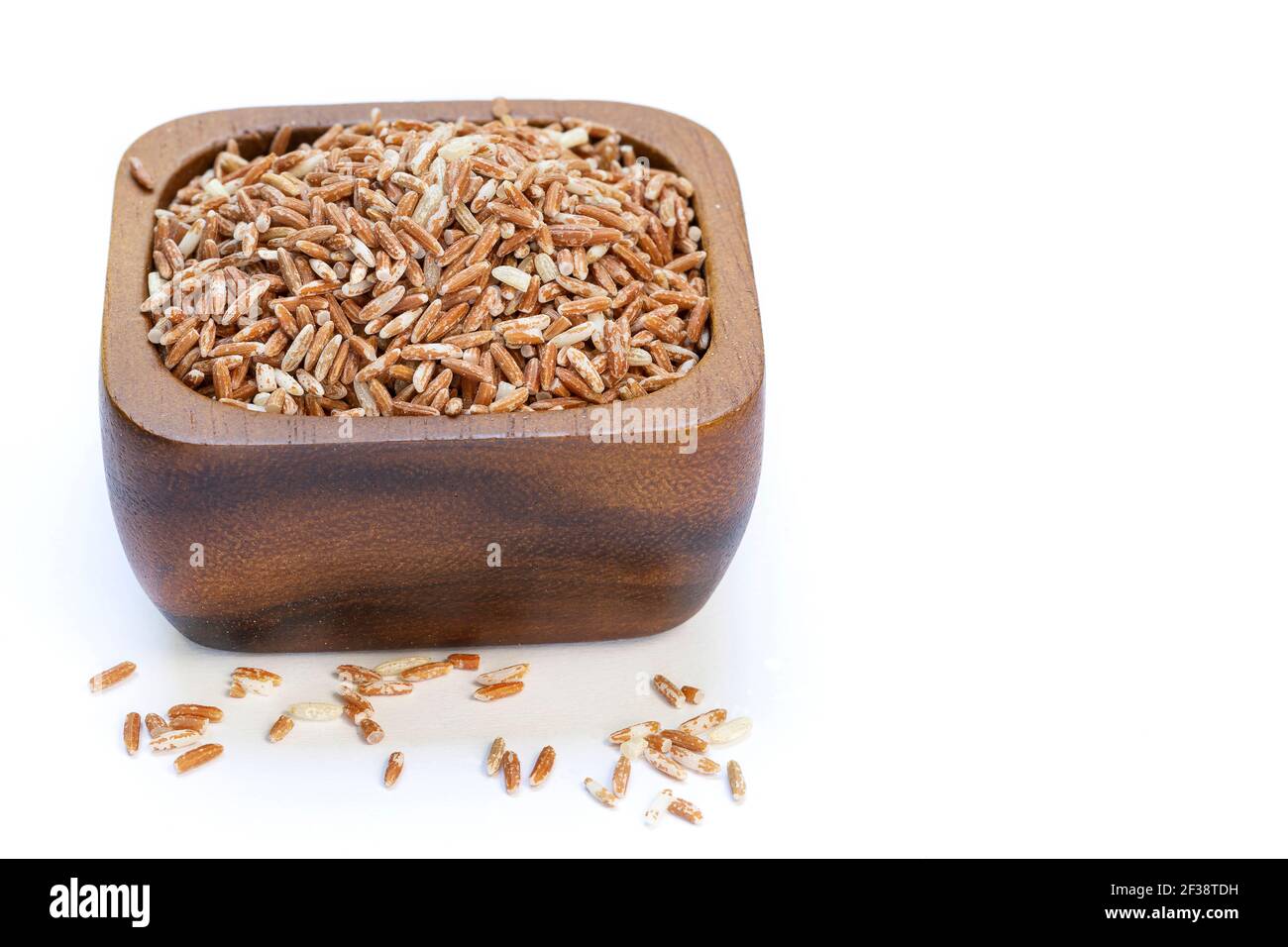 Raw red rice in a wooden cup isolated on white background Stock Photo ...