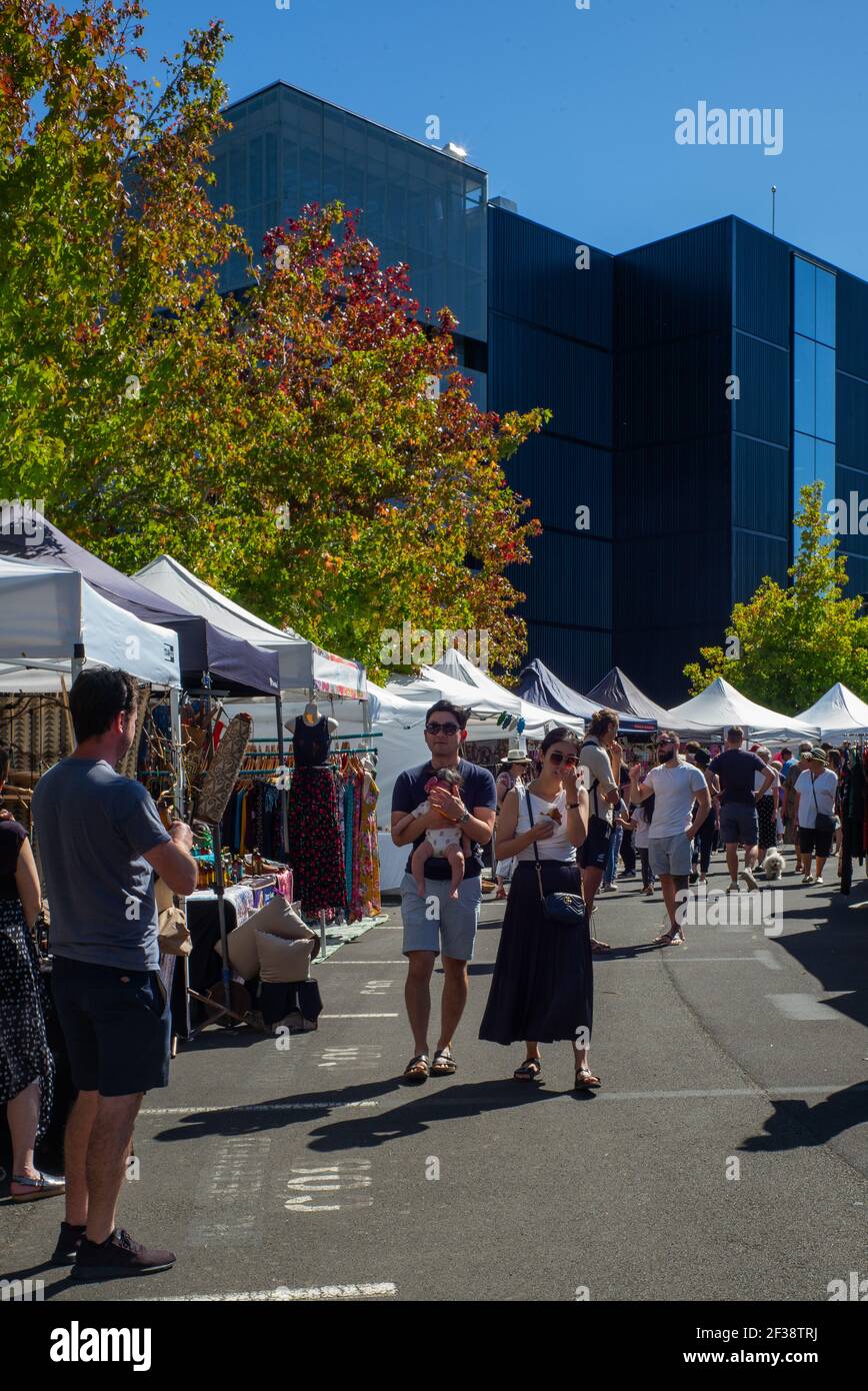 A couple with a baby at Smales Farm Sunday Market, Takapuna, Auckland, a place to meet, drink coffee, and look at and buy handcrafts. Stock Photo
