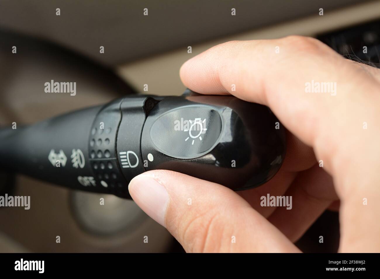 Hand adjusting car headlight control switch Stock Photo