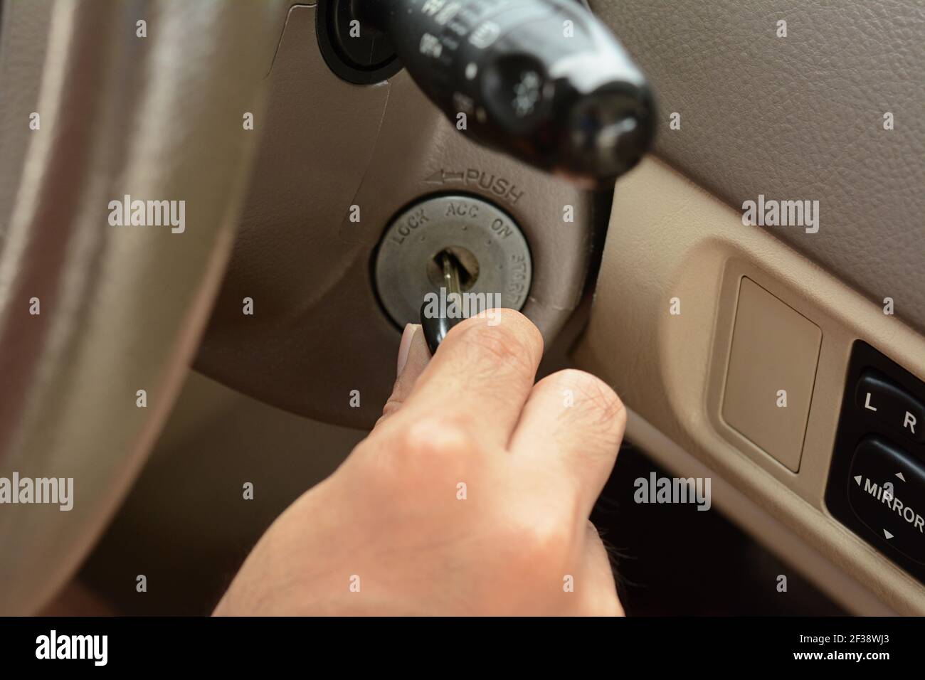 Hand putting car key on the keyhole Stock Photo