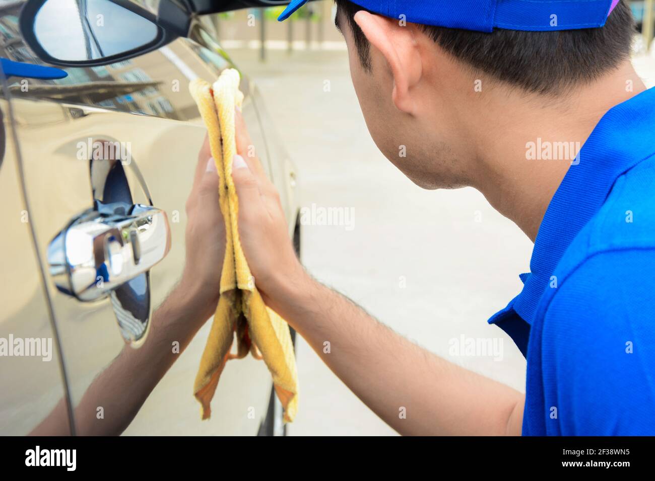A man polishing car with microfiber cloth, car detailing (or valeting