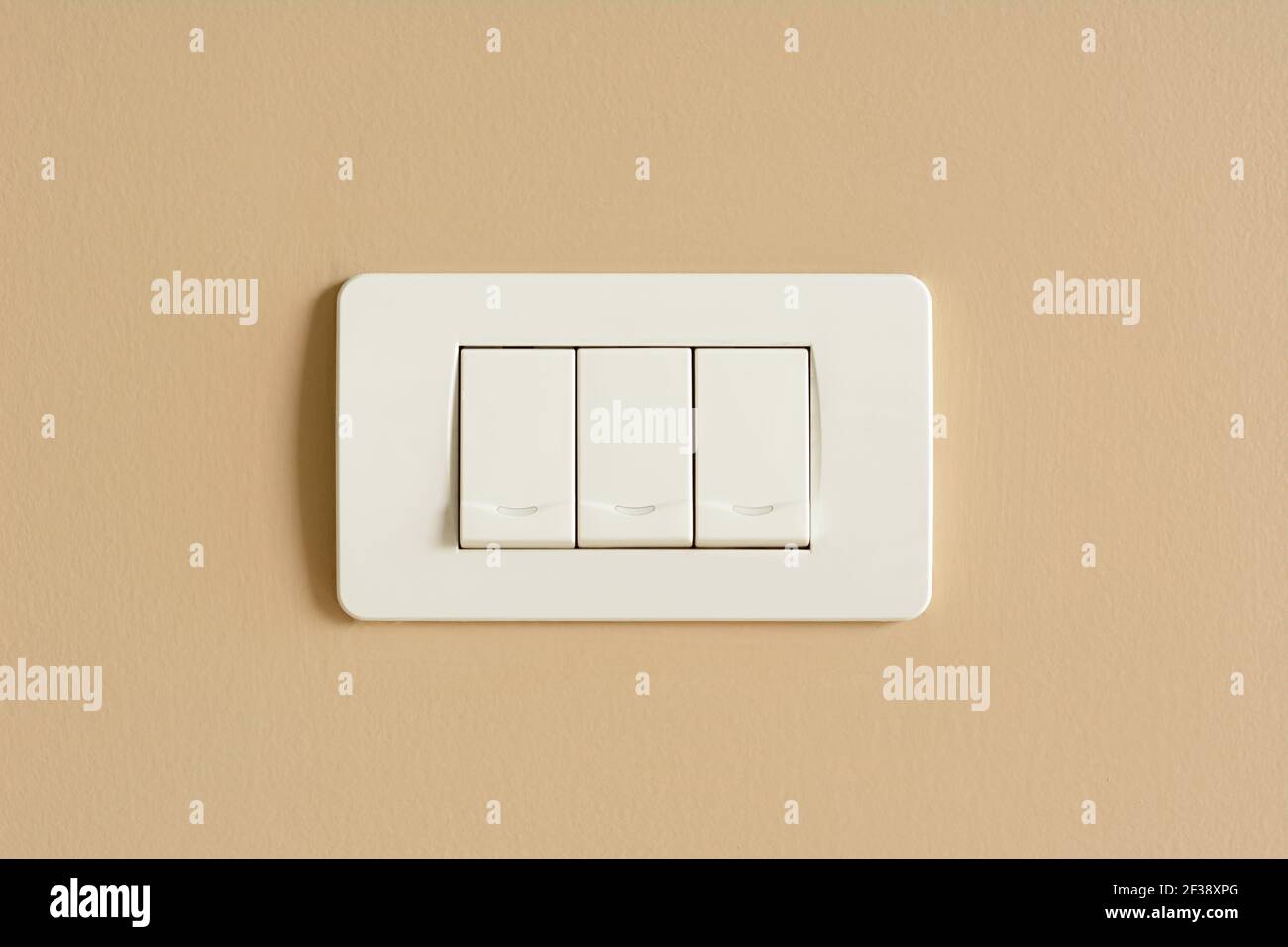Triple light switches on colored concrete wall Stock Photo Alamy