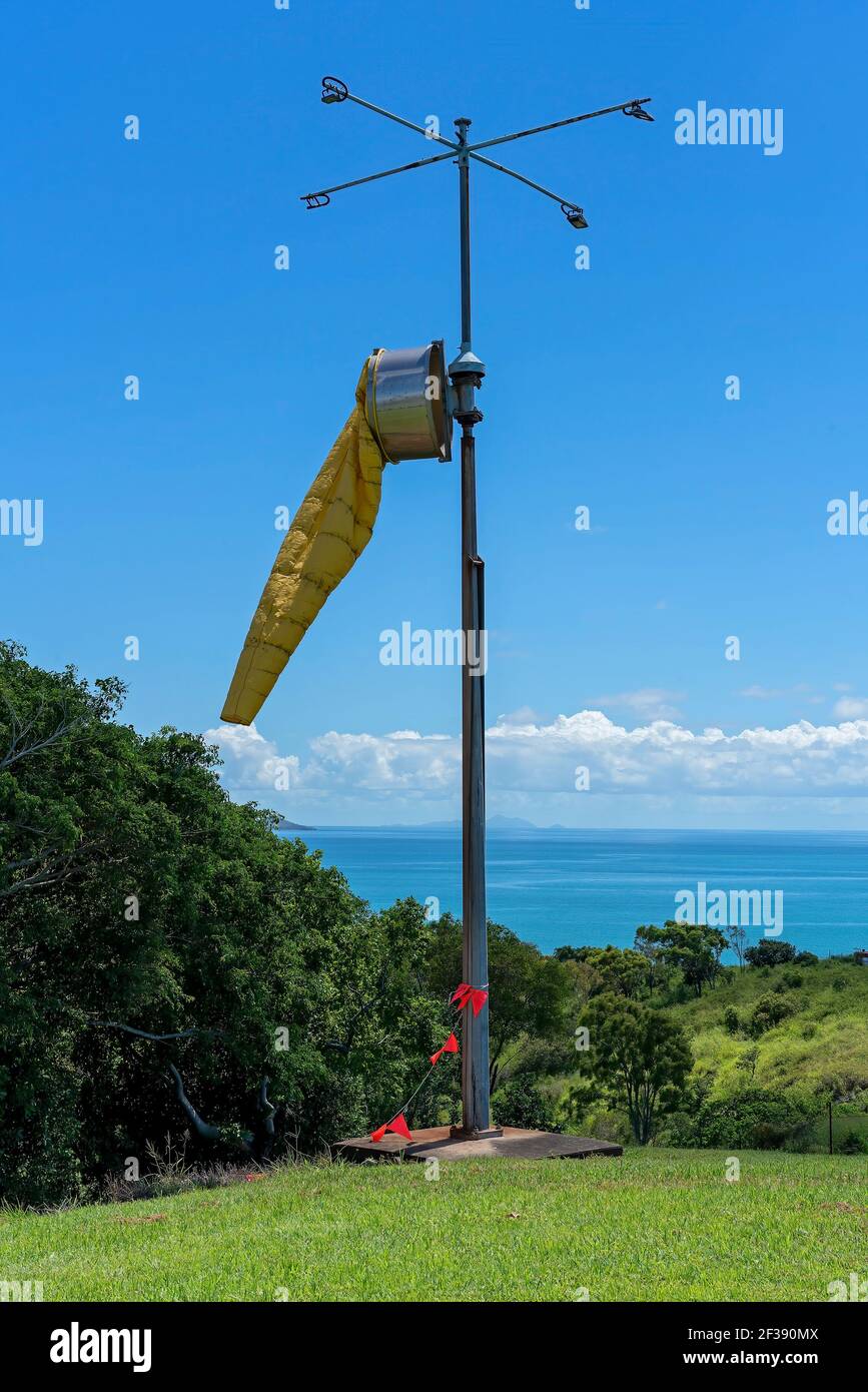 A yellow windsock to measure wind speed and direction against a clear