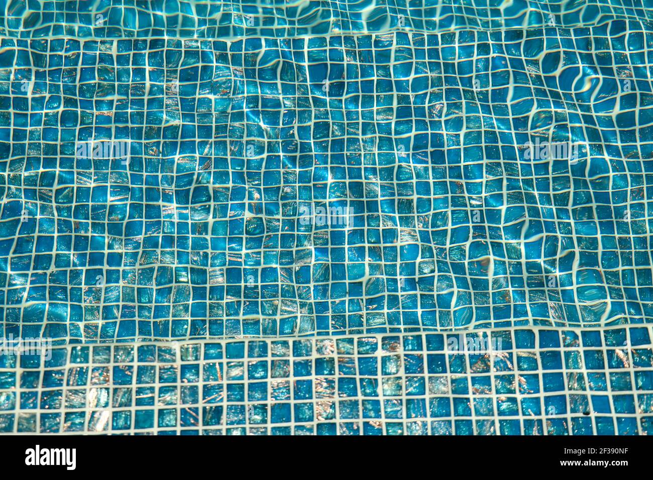 A pool with blue ceramic tiles and water ripple effect. Refection of