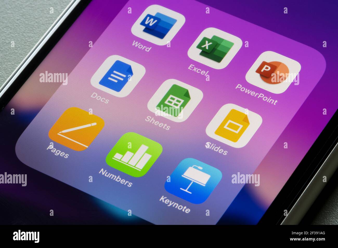 Office suites of apps created by Microsoft, Google, and Apple are seen on an iPhone - Word, Excel, PowerPoint, Docs, Sheets, Slides, Pages, Numbers... Stock Photo