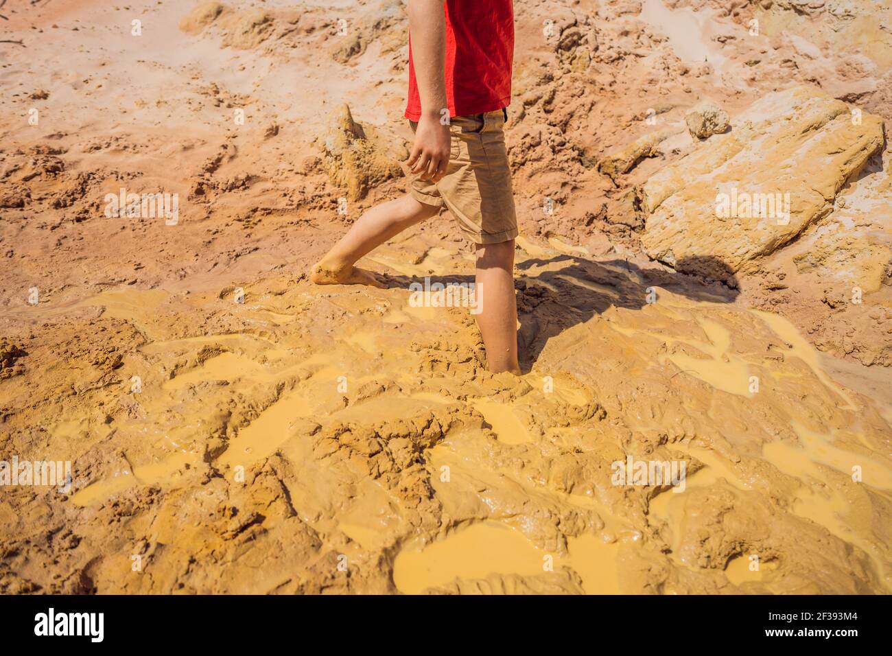 Unlucky buried person standing in natural quicksand river, clay sediments, sinking, drowning quick sand, stuck in the soil, trapped and stuck concept Stock Photo