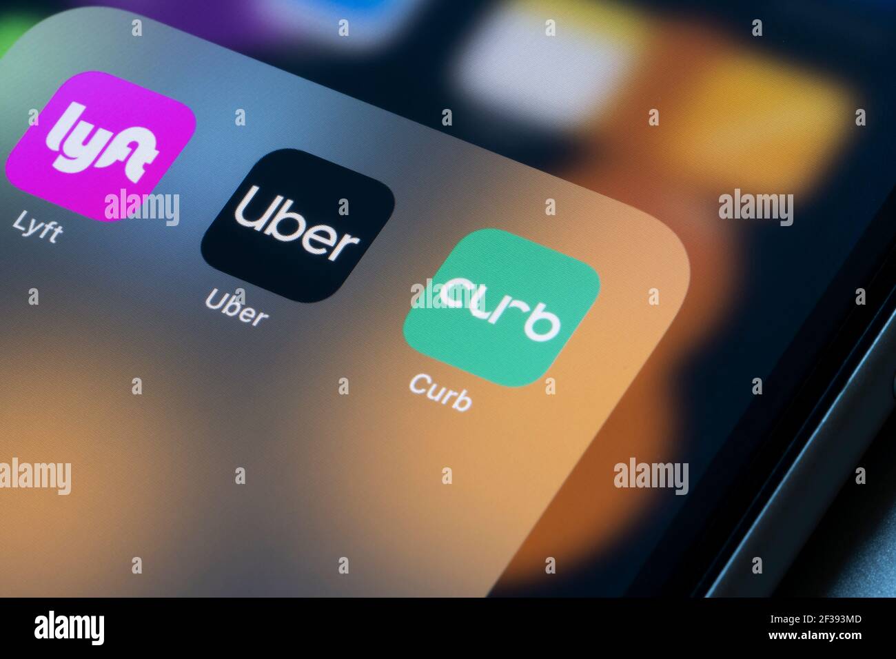 Uber, and Curb ridesharing app icons are seen on an iPhone. Stock Photo