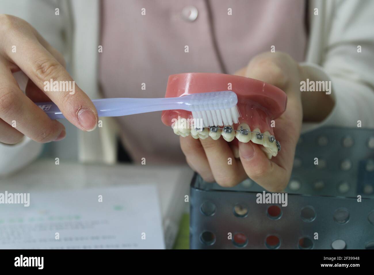 Dental professional showing how to brush with braces Stock Photo Alamy