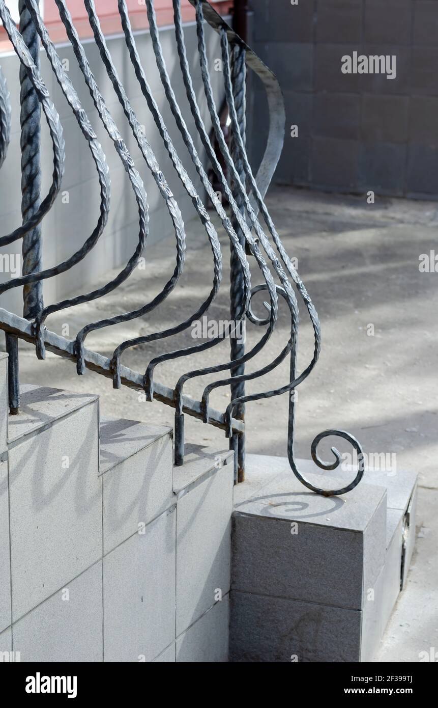 Gray stone staircase with wrought iron railings. Graceful railings ...