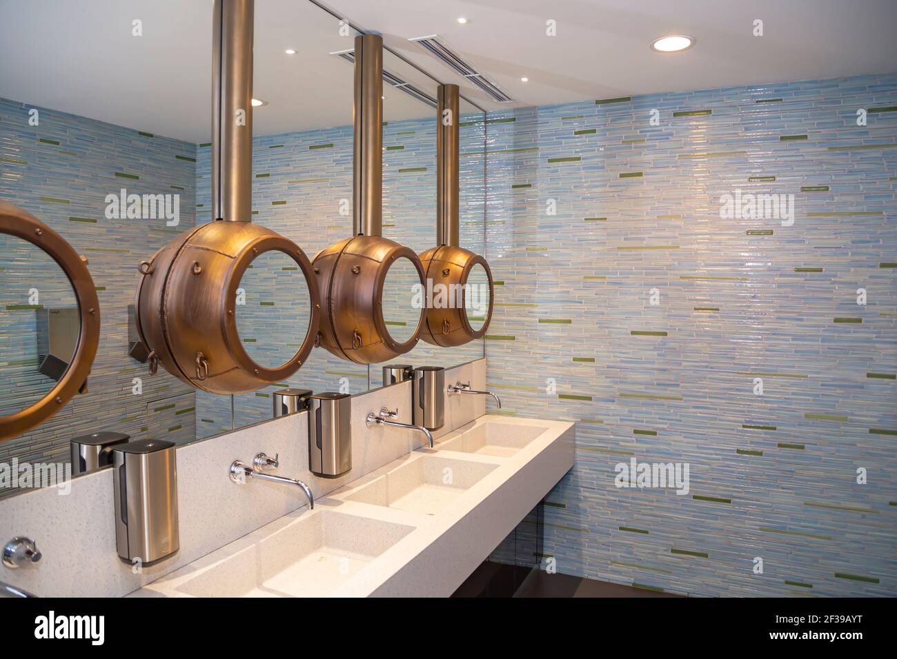 Faucets with washbasin in public restroom in grey colors Stock Photo