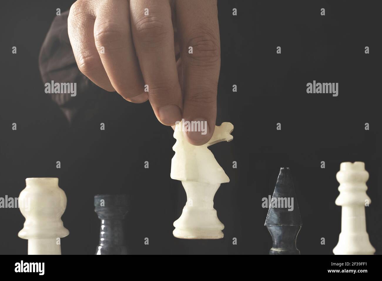 The chess player makes the winning move of the game, the concept of strategy to achieve success Stock Photo