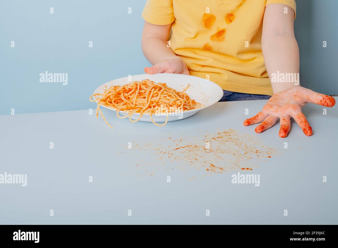 Dirty child hands from tomato spaghetti sauce bolognese. concept of dirty stains on clothes
