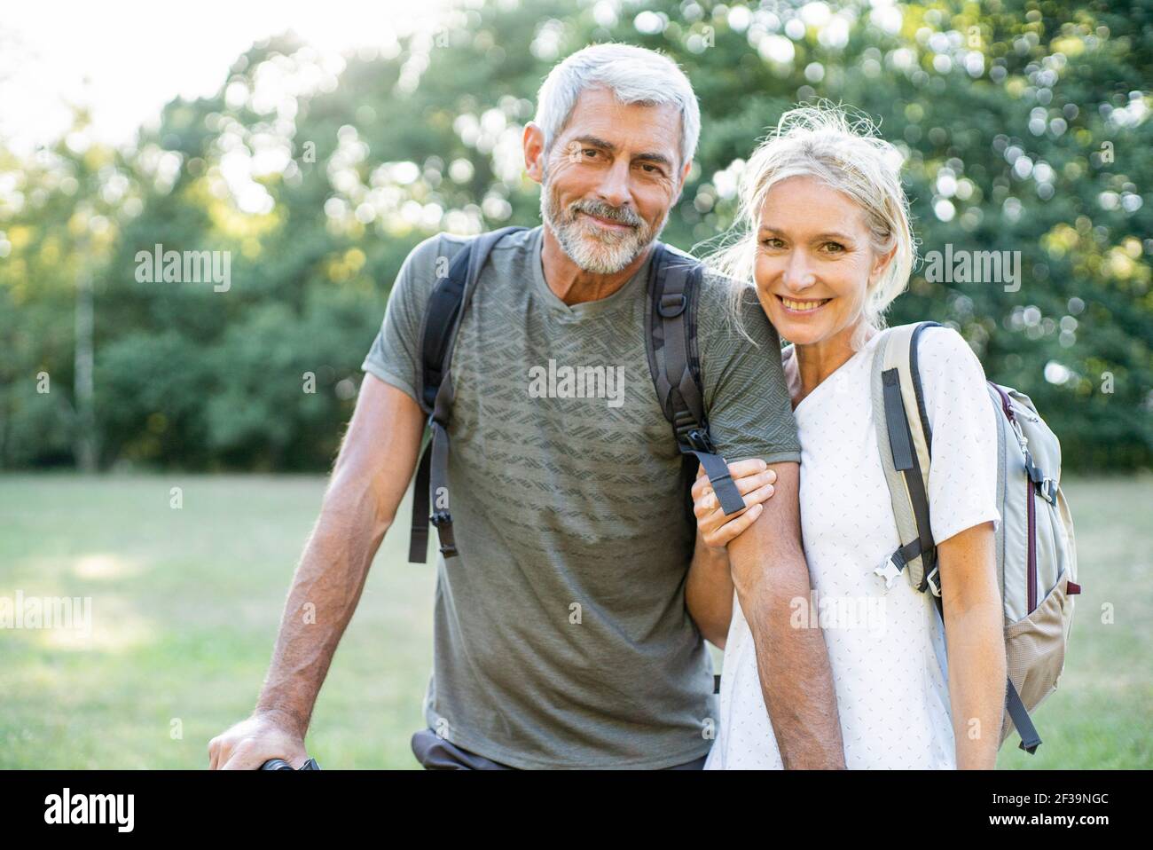 Portrait of smiling mature couple standing in forest Stock Photo