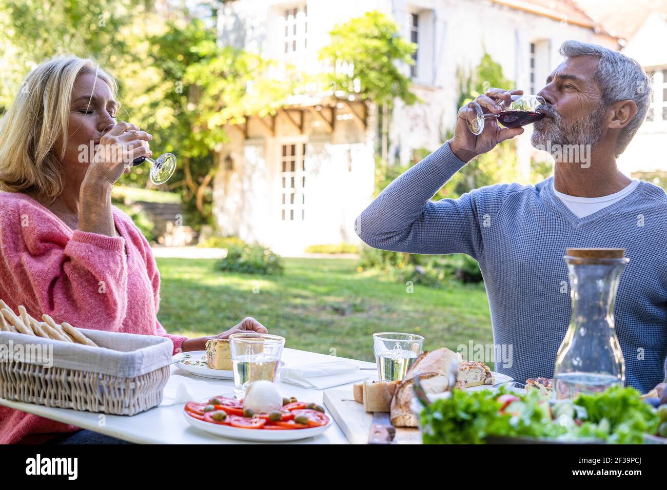 Mature couple drinking red wine while sitting at table Stock Photo