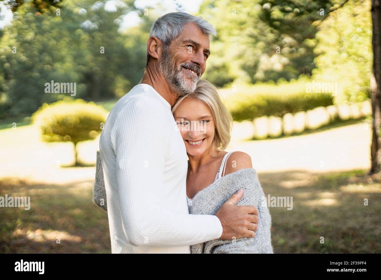 Happy mature couple hugging in backyard Stock Photo