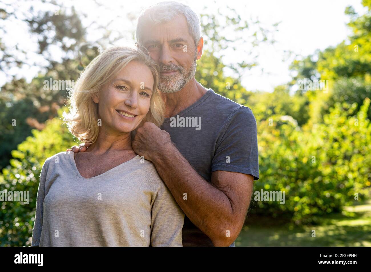 Portrait of smiling mature couple standing in backyard Stock Photo - Alamy
