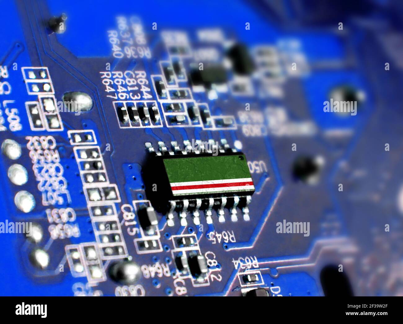Electronic board with embedded microchip and shown flag of Chechen Republic of Ichkeria. The concept of modern computer technologies. Stock Photo
