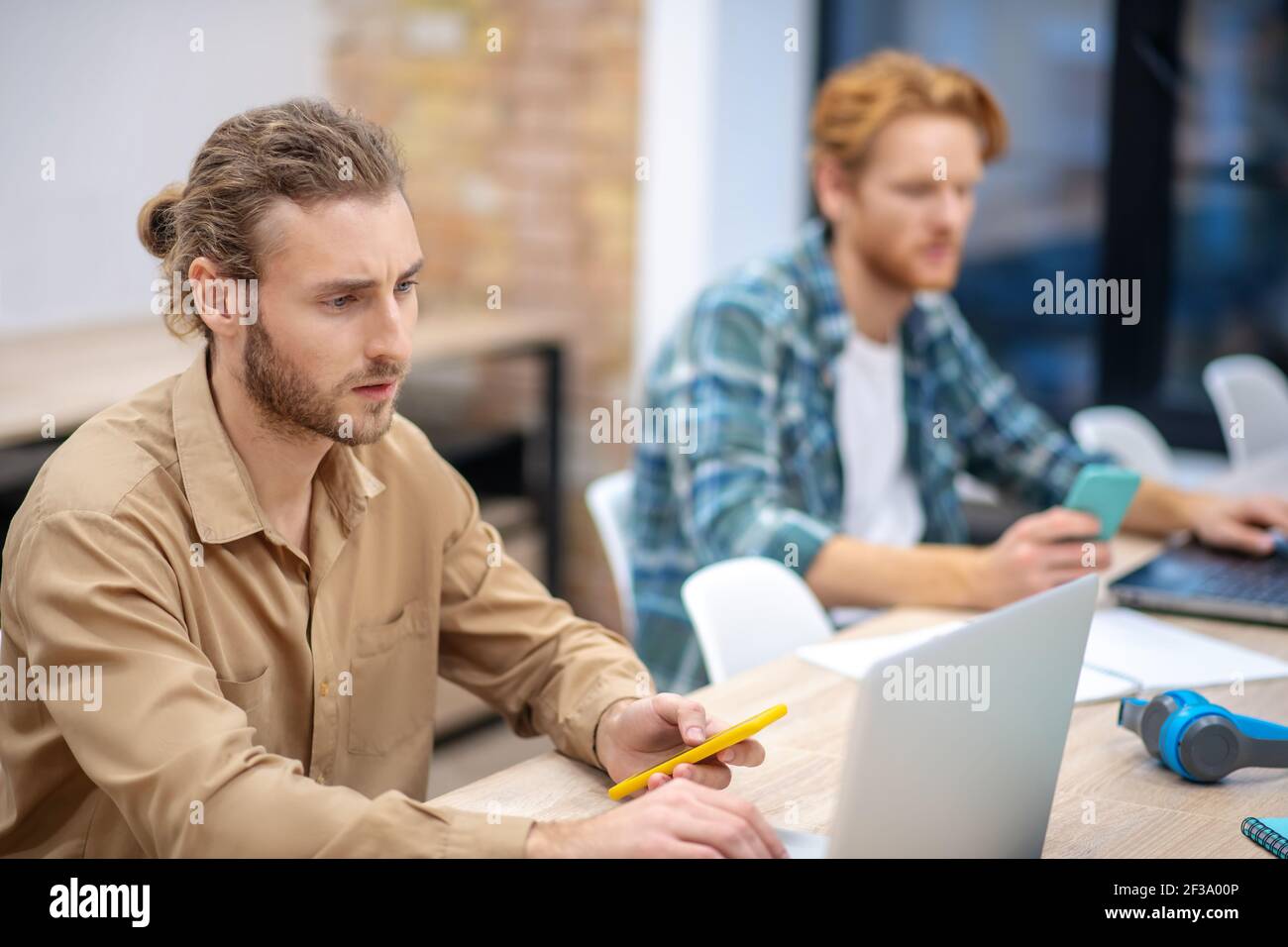 Busy day. Two guys looking serious while working on the laptops Stock Photo