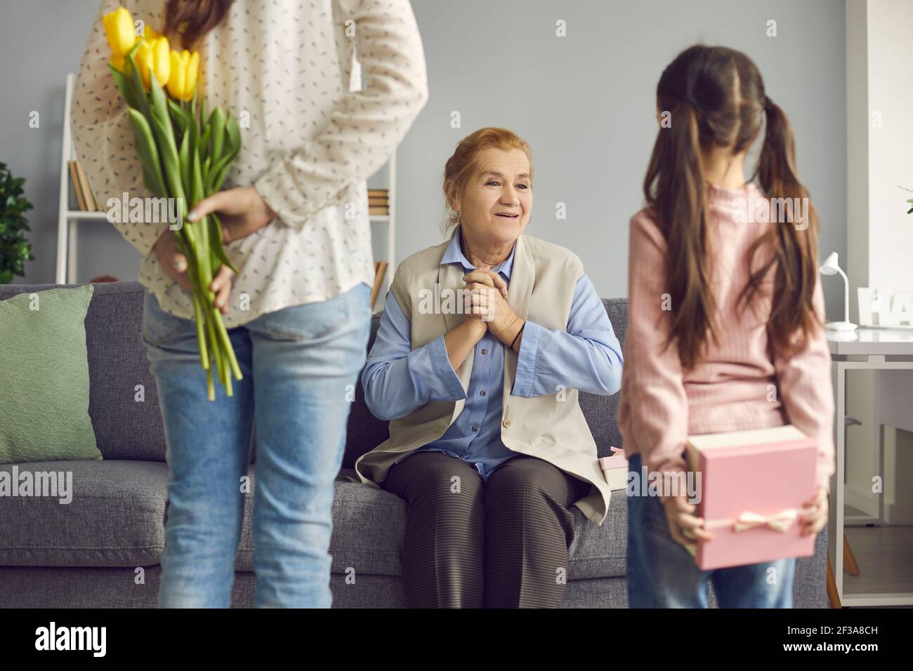 Old woman is happy that her daughter and granddaughter are going to congratulate her on the holiday. Stock Photo