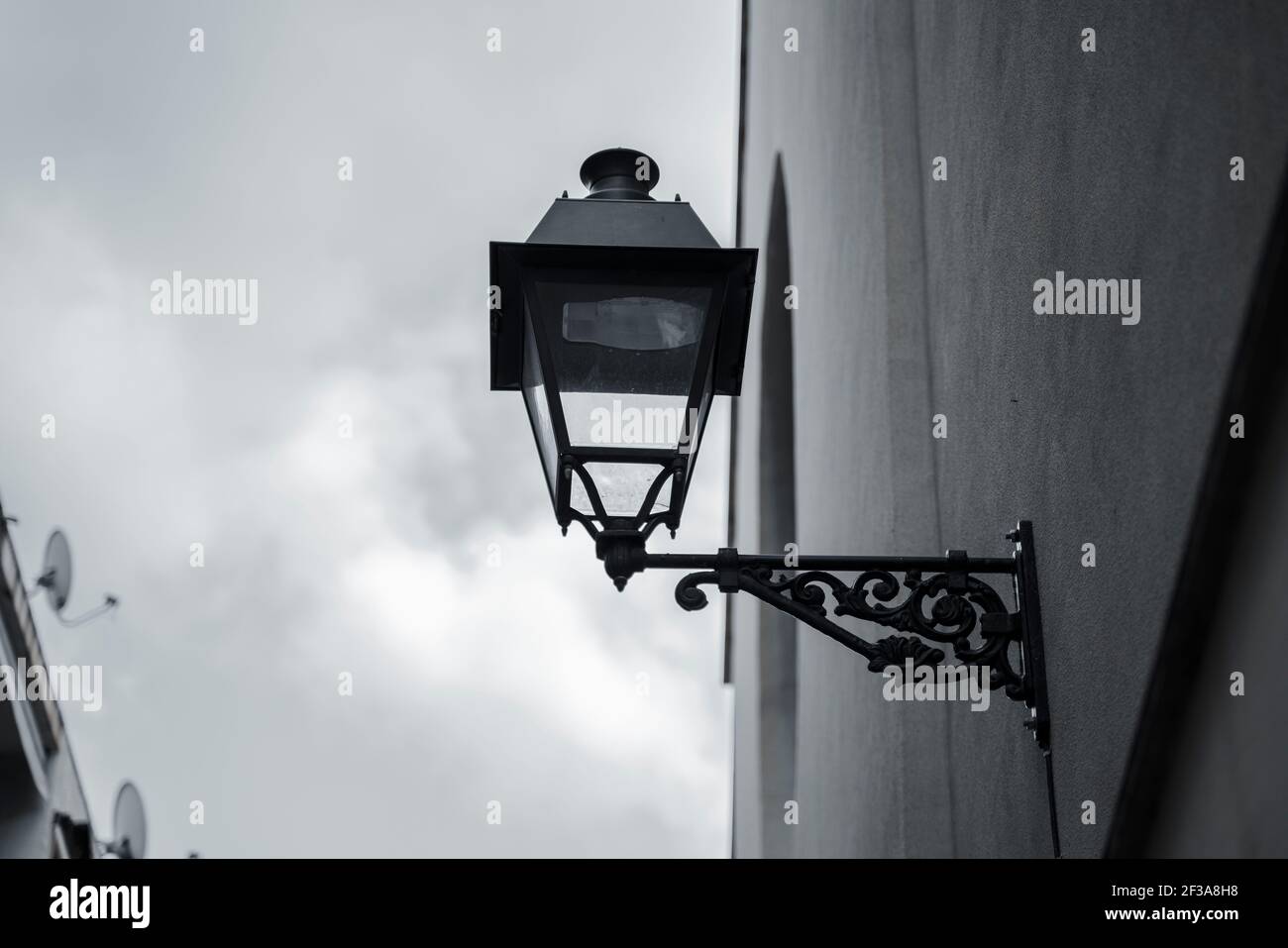 Street lamp seen from below with the blue sky in the background with some clouds Stock Photo
