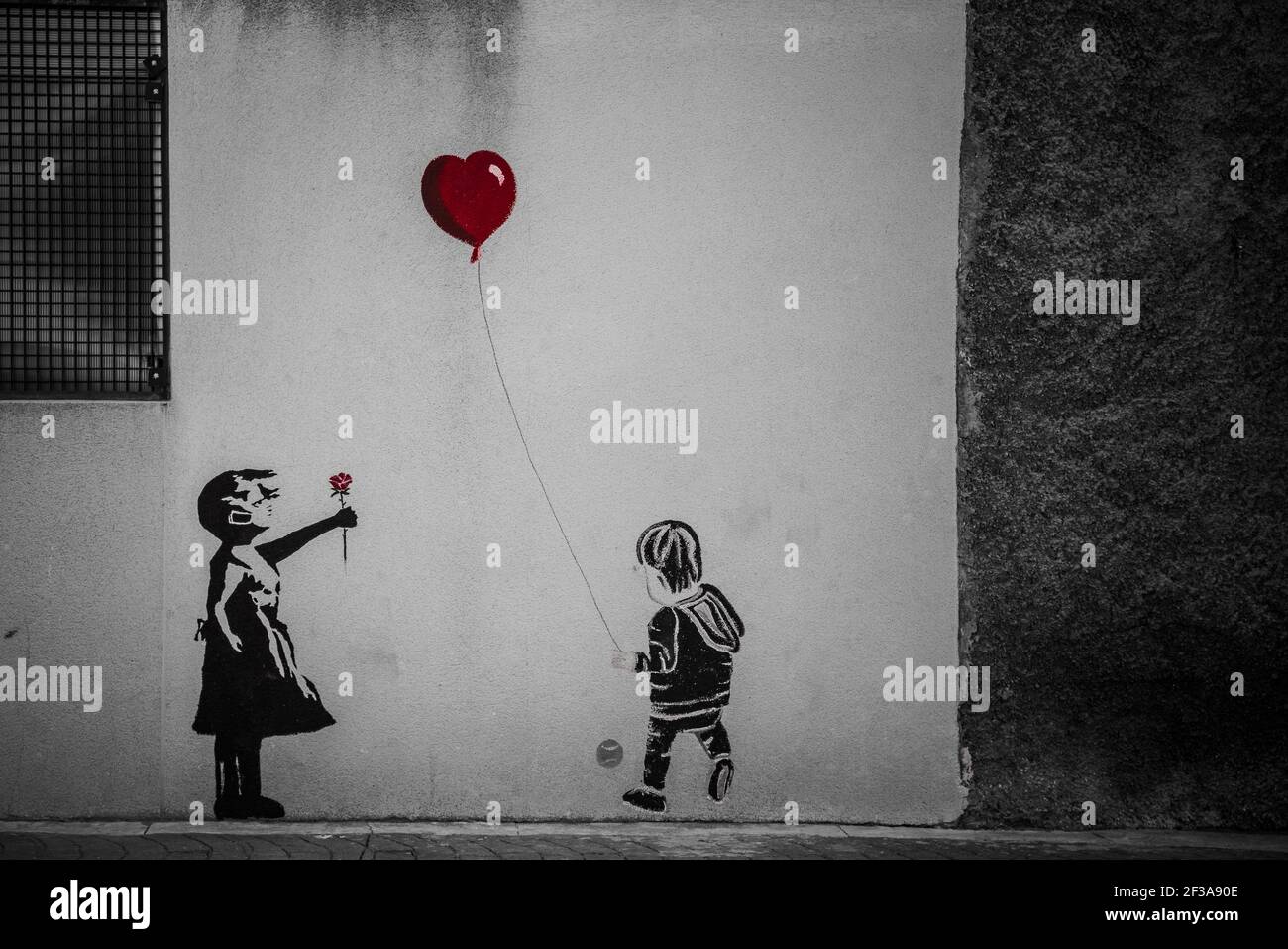 Graffiti of children playing with red balloon Stock Photo