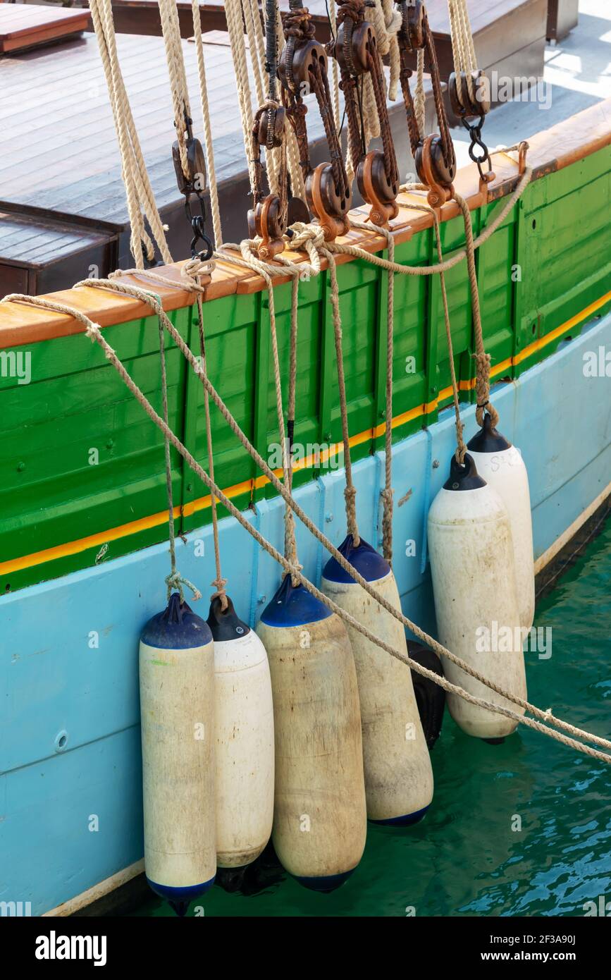 Buoys hanging outside the hull of an ancient colorfull wooden sailing boat Stock Photo