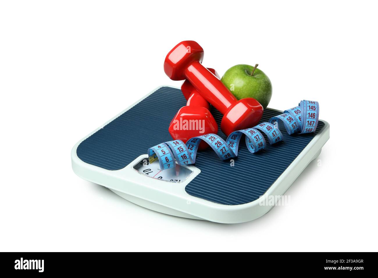 Bathroom scale with red dumbbells, a green apple and a blue measuring tape isolated on white, weight control concept Stock Photo